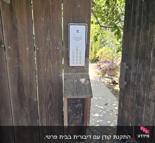 אינטרקום מותקן על גדר עץ עם לוח מקשים